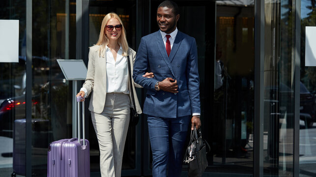 Portrait Of Young Diverse Man And Woman Leaving Hotel, Polite Black Man Hold Woman's Hand, They Are In Love, Carrying Bags