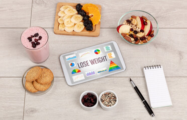 Organic food and tablet pc showing LOSE WEIGHT inscription, healthy nutrition composition