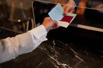 unrecognizable lady give documents to woman on reception, business woman on business trip, she has booked this hotel