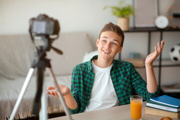 Cheerful teenager broadcasting from home, sharing his thoughts with followers