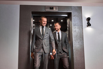 businessmen leave the elevator, two caucasian men after co-working. business people concept