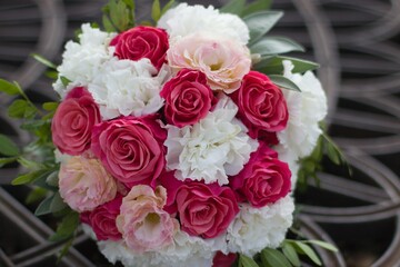 Wedding pink and white bouquet laid on a metal grate for a happy day