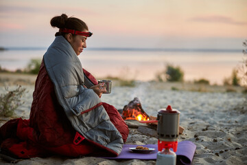 Charming female traveler enjoying hot drink outdoors