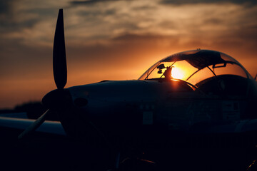 Small private single engine propeller airplane at sunset regional airport.