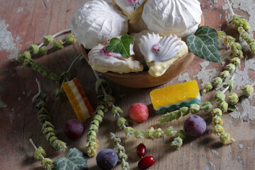 Sweet dessert with dogwood berries, plums and leaves on a wooden table