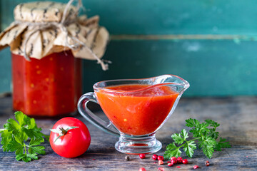 Homemade sauce made from ripe red tomatoes in glass jars. Copy space