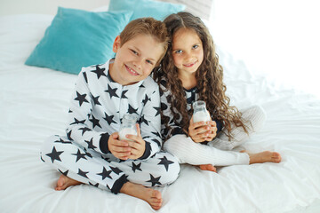 Children drink milk. Boy and girl at home. High quality photo.