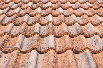 Close up of brown clay roof tiles. Red old dirty roof. Old roof tiles. Construction equipment build a house.