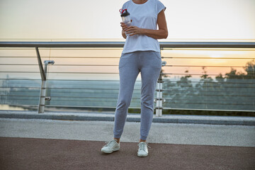 Female athlete standing on a pedestrian bridge