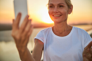 Merry woman taking selfies in the evening