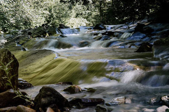 Krajobraz kaskady wodne z dużymi głazami i roślinnością na brzegach