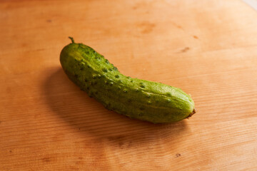 green cucumber on a wooden background. With copy space.