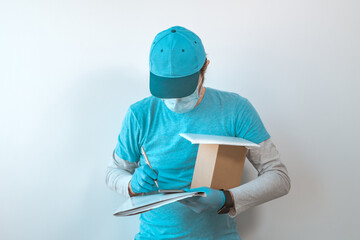 Delivery worker with protective gloves completing package documentation
