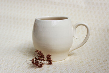 Obraz na płótnie Canvas white clay mug on a beige background. Handmade. covered with transparent glaze, two firing