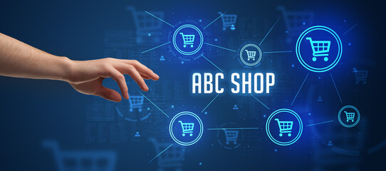 Close-Up of cropped hand pointing at ABC SHOP inscription, online shopping concept