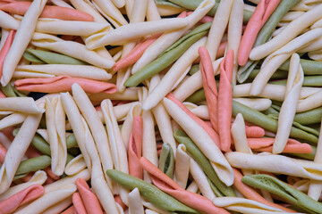Uncooked rotini or fusilli pasta. Italian egg pasta as background
