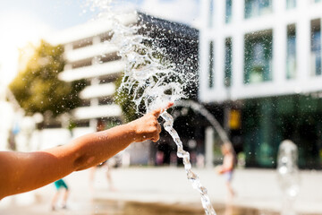 Abkühlung mit Wasser im öffentlichen Raum in der Stadt. Hitze in der Stadt.