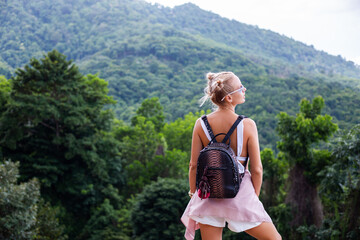 European stylish woman blogger tourist stands on the top of mountain with amazing tropical view of Koh Samui island, Thailand. Fashion outdoor portrait of female.  