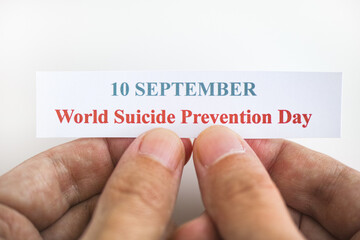 Person holding piece of paper with the words World Suicide Prevention Day