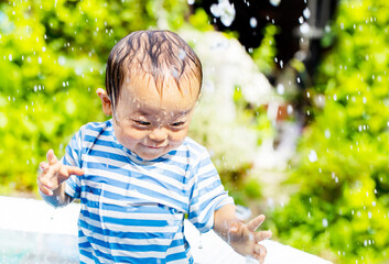 外で水遊びで大はしゃぎしている子供　ずぶ濡れの子供