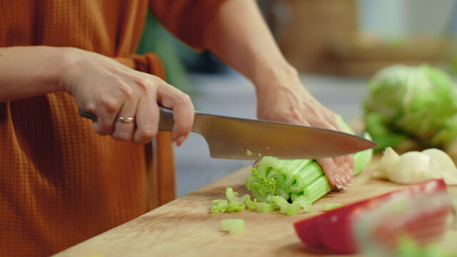 Woman Hands Chopping Celery On Cutting Board. Housewife Cooking Fresh Vegetables