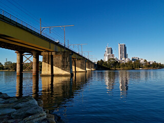 Obraz premium Beautiful view of a railway bridge across a river on a sunny day with deep blue sky, Parramatta river, Meadowbank, Sydney, New South Wales, Australia