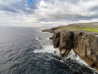 Aerial drone view, landscape in Burren region, county Clare  Ireland. Mini cliffs and Atlantic ocean, Part of Wild Atlantic Way route. Popular tourist attraction. Cloudy sky.