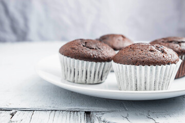 bakery chocolate cupcakes in a dish on a white background