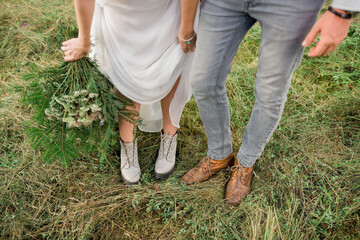 Fototapeta na wymiar Beautiful bride and groom. close-up wedding shoes. bride with flowers in mountains, beautiful nature, landscape, sunset