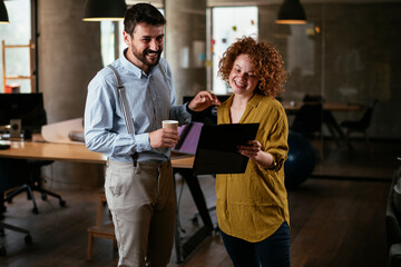 Colleagues in office. Businesswoman and businessman discussing work in office. Two friends in working together..