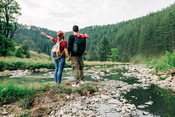 Young couple exploring nature by the mountain river