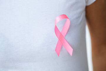 Woman using pink ribbon to support breast cancer cause or AIDS