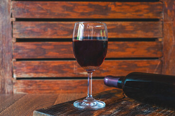 .Wine glass and wine bottle on the wooden table
