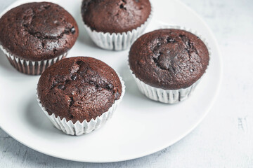 bakery chocolate cupcakes in a dish on a white background