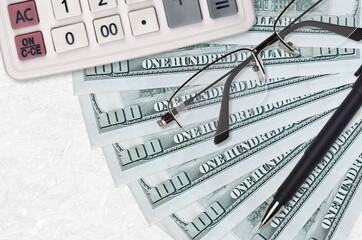 100 US dollars bills fan and calculator with glasses and pen. Business loan or tax payment season...