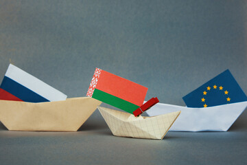 paper boat with the flag of belarus (unofficial) and other flags of neighboring states, russia, poland, europe.