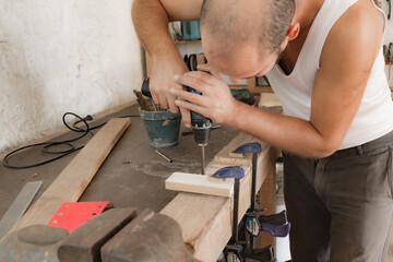 Male carpenter working on old wood in a retro vintage workshop.