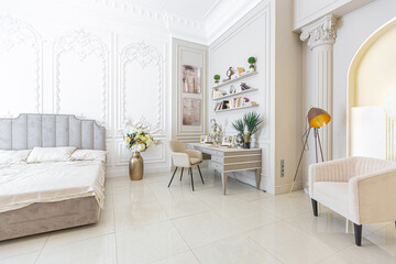 chic luxury interior in an old antique style open-plan apartment decorated with columns and stucco on the wall in pastel colors. tiles on the floor. beige walls