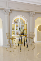 chic luxury interior in an old antique style open-plan apartment decorated with columns and stucco on the wall in pastel colors. tiles on the floor. beige walls