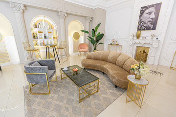 chic luxury interior in an old antique style open-plan apartment decorated with columns and stucco on the wall in pastel colors. tiles on the floor. beige walls