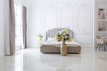 chic luxury interior in an old antique style open-plan apartment decorated with columns and stucco on the wall in pastel colors. tiles on the floor. beige walls