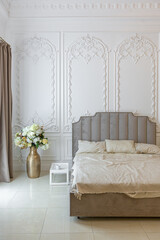 chic luxury interior in an old antique style open-plan apartment decorated with columns and stucco on the wall in pastel colors. tiles on the floor. beige walls