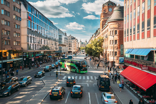Stockholm, Sweden. Red Hop On Hop Off Touristic Bus For Sightseeing Riding Down The Vasagatan Street. City Tour Bus.