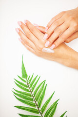 Closeup of beautiful female hand applying hand cream