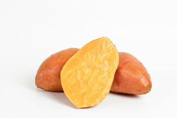 Farm raised organic sweet potato tubers laid in composition on textured background. The edible tuberous root vegetable on table counter. Clean eating concept. Background, close up, flat lay, top view.