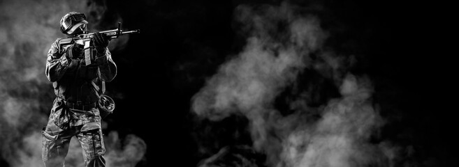 Soldier of special forces aiming on target.  Infantryman fighting with terrorism. Commando on smoky...