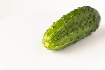 Fresh green cucumber on a light background. The concept of natural food. Selective focus.