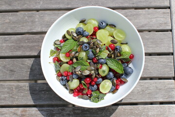 colorful fruit salad with pumpkin seeds on top