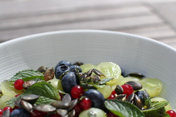 colorful fruit salad with pumpkin seeds on top