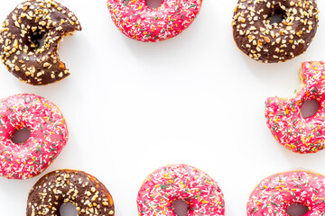Frame of donuts with icing and sprinkles, overhead view. Colorful bakery